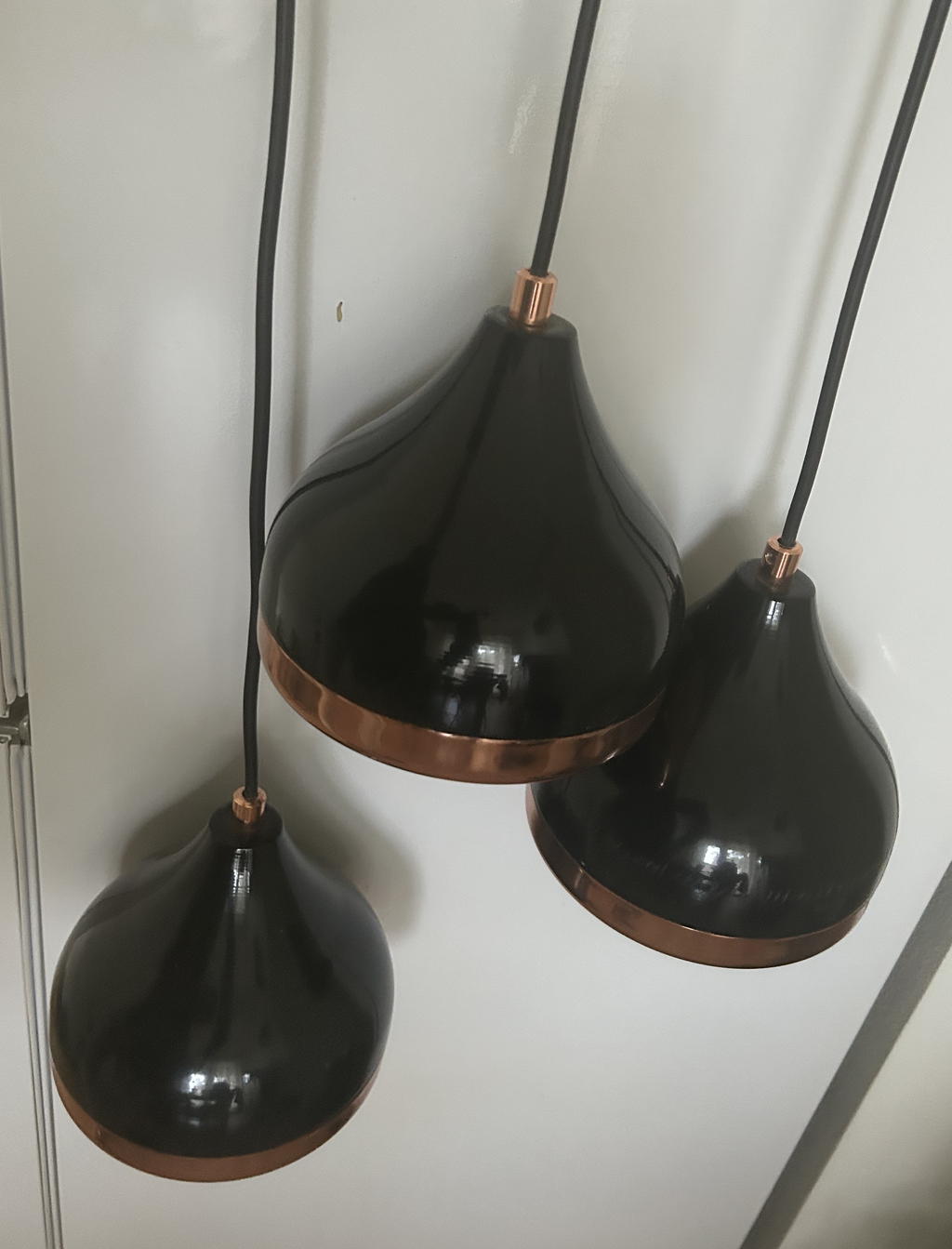 Design hanglamp met 3 in lengte verschillende lampen. Kleur zwart met koperen bies